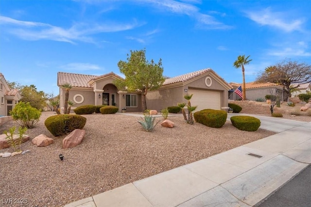 view of front of home featuring stucco siding, driveway, a tile roof, and a garage