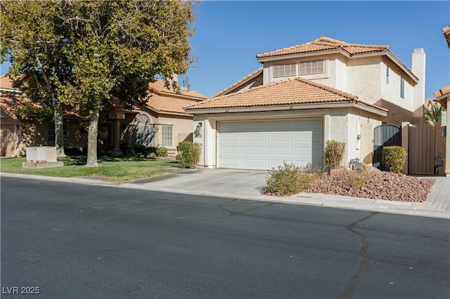 mediterranean / spanish house with a gate, driveway, an attached garage, stucco siding, and a tiled roof