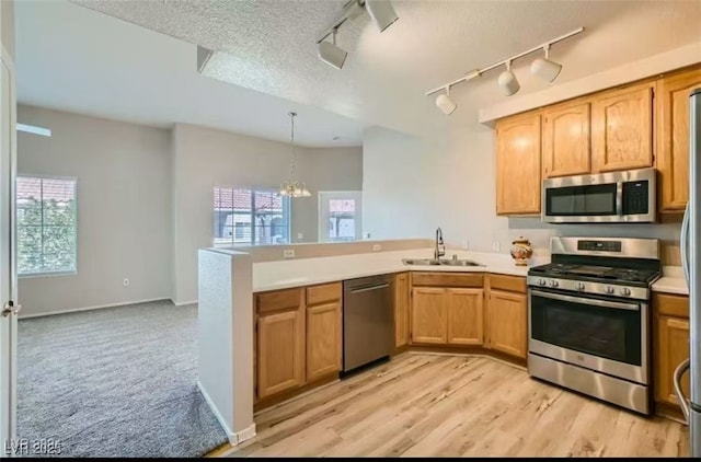 kitchen with a sink, plenty of natural light, appliances with stainless steel finishes, and a peninsula