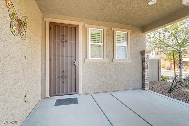 view of exterior entry with stucco siding