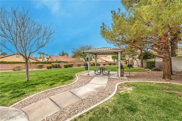 view of community with a gazebo, a lawn, and fence