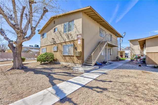 back of property featuring stairs and fence