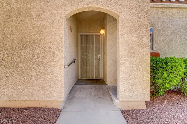 view of exterior entry with stucco siding