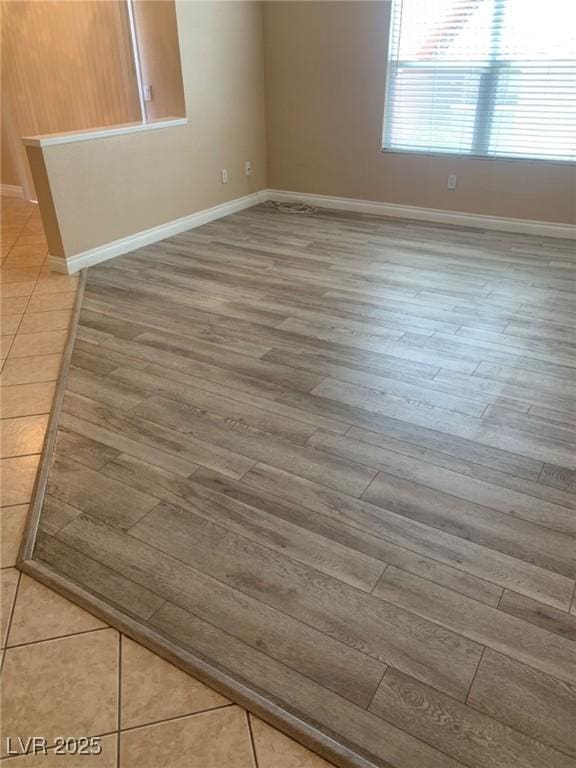 empty room featuring baseboards and wood finished floors