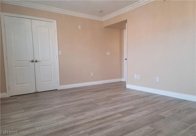 unfurnished bedroom featuring a closet, baseboards, ornamental molding, and light wood finished floors