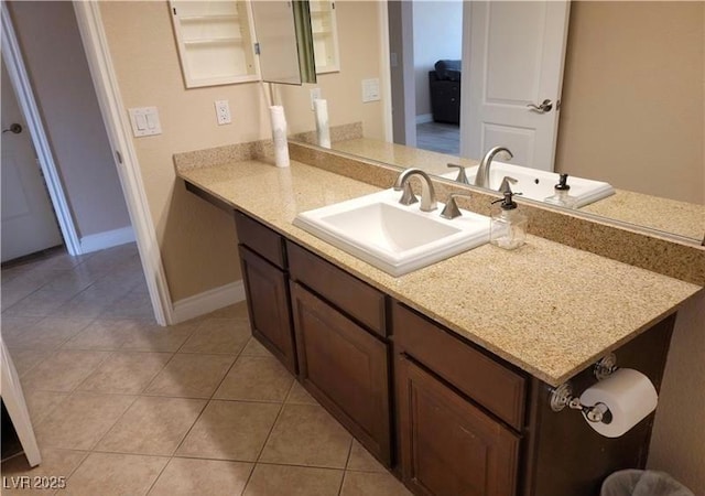 bathroom with tile patterned floors, baseboards, and vanity