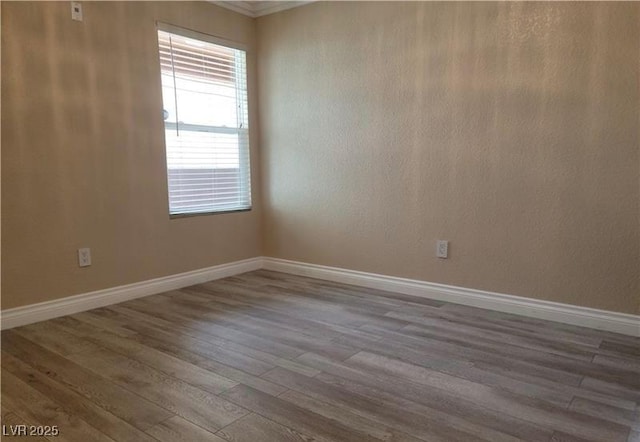 spare room with wood finished floors and baseboards