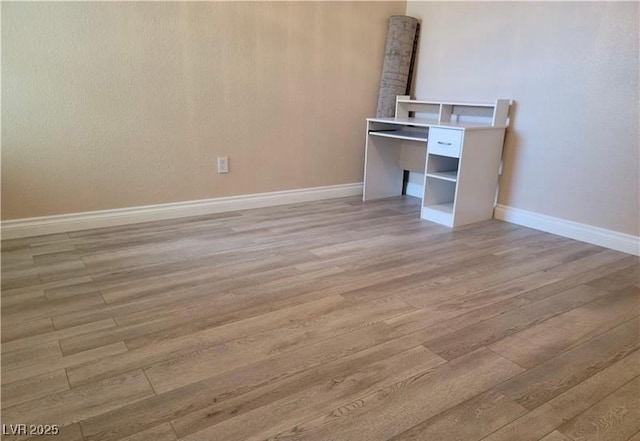 interior space with baseboards and light wood finished floors