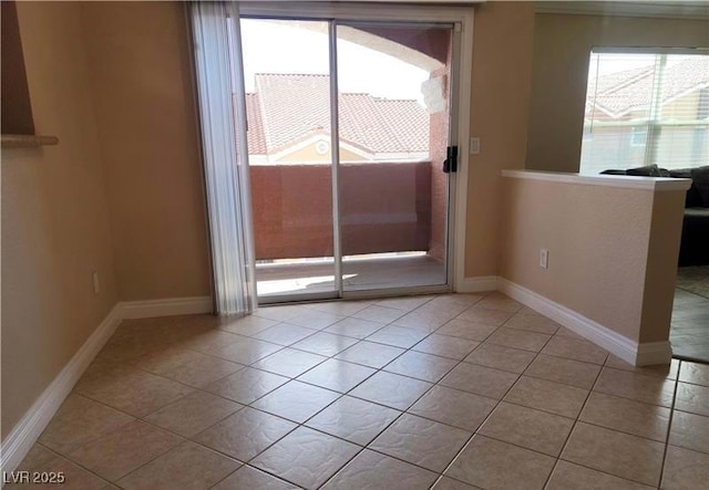 unfurnished room with light tile patterned floors and baseboards