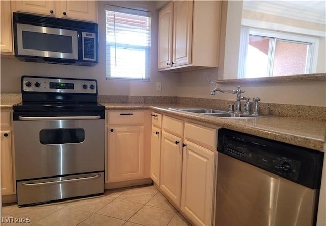 kitchen with light countertops, light tile patterned floors, appliances with stainless steel finishes, and a sink