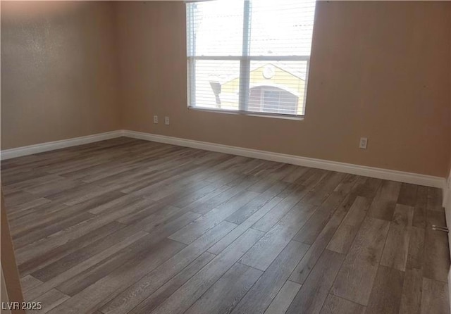 spare room featuring wood finished floors and baseboards