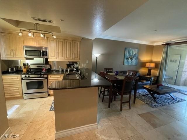 kitchen with dark countertops, crown molding, visible vents, and stainless steel appliances