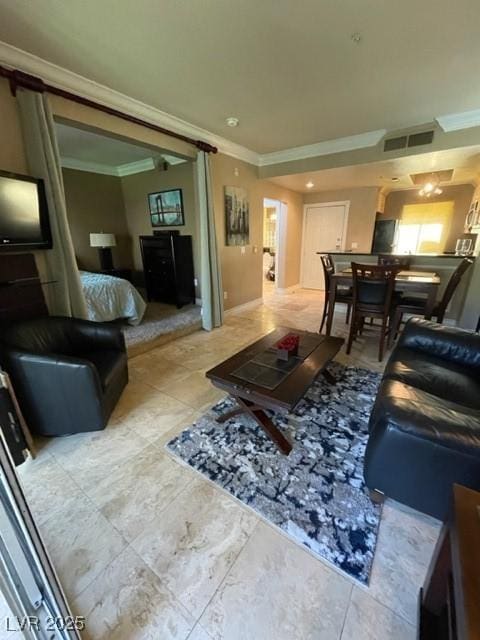 living area featuring visible vents, a barn door, and ornamental molding