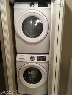 washroom featuring stacked washer / drying machine