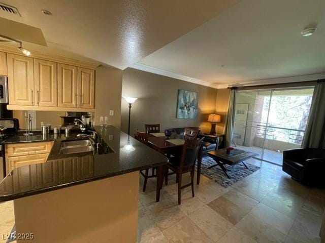 kitchen featuring stainless steel microwave, visible vents, ornamental molding, a peninsula, and a sink