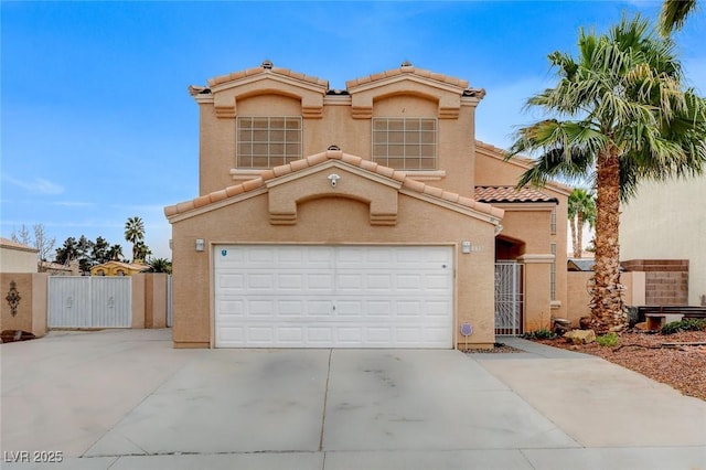 mediterranean / spanish-style home with a tiled roof, stucco siding, a garage, driveway, and a gate