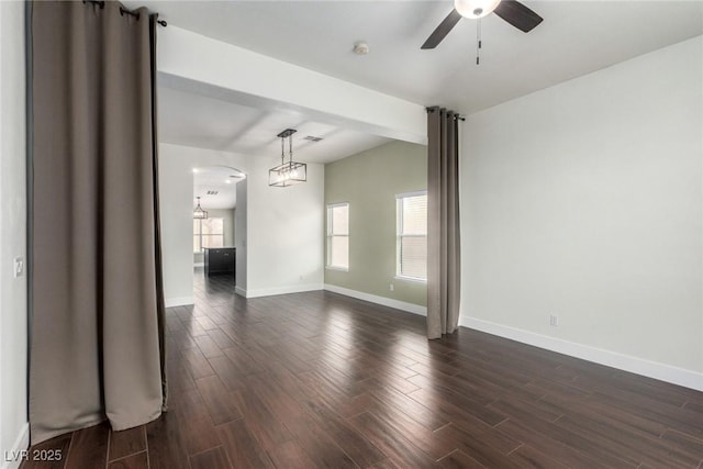 empty room featuring dark wood-style floors, baseboards, and ceiling fan