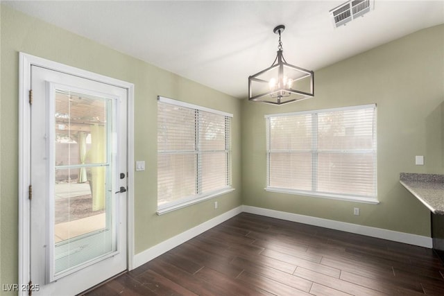 unfurnished dining area with an inviting chandelier, baseboards, visible vents, and dark wood-style flooring