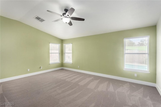 empty room with visible vents, lofted ceiling, ceiling fan, and carpet flooring