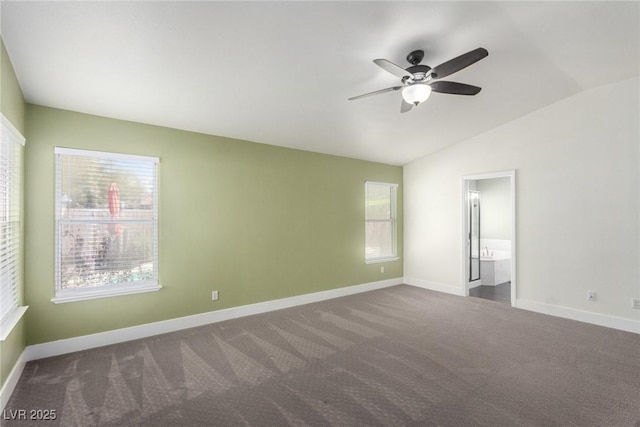 unfurnished bedroom with carpet, baseboards, a ceiling fan, ensuite bath, and vaulted ceiling