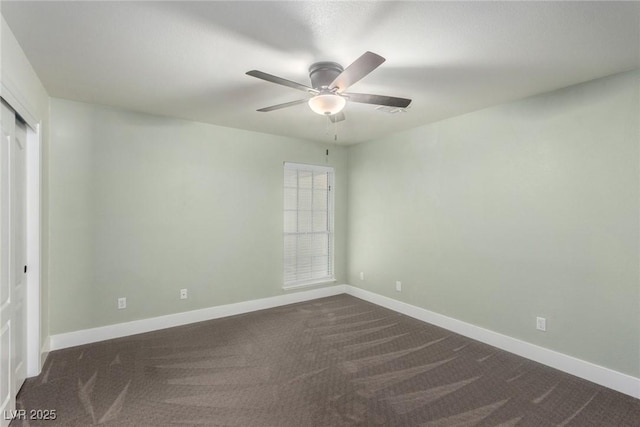 empty room featuring dark carpet, baseboards, and a ceiling fan