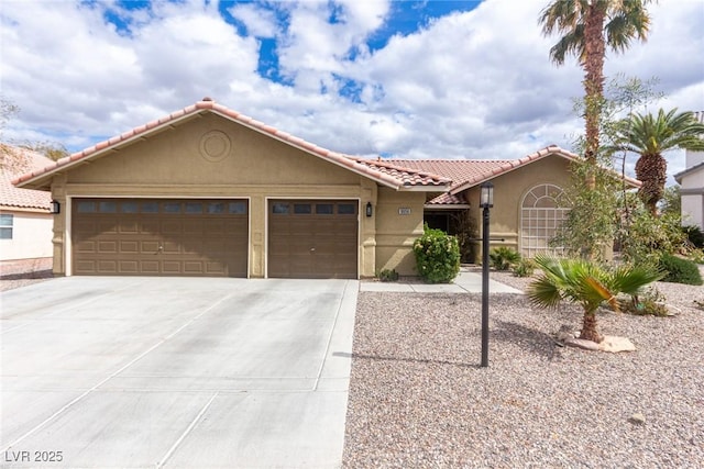 view of front of home with a tile roof, concrete driveway, a garage, and stucco siding