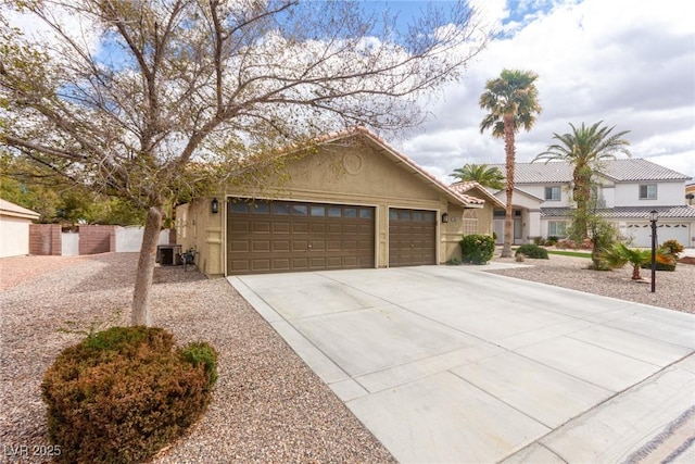 view of front of house featuring a garage, central air condition unit, concrete driveway, and stucco siding