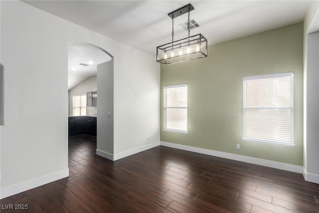 empty room featuring arched walkways, visible vents, dark wood finished floors, and baseboards