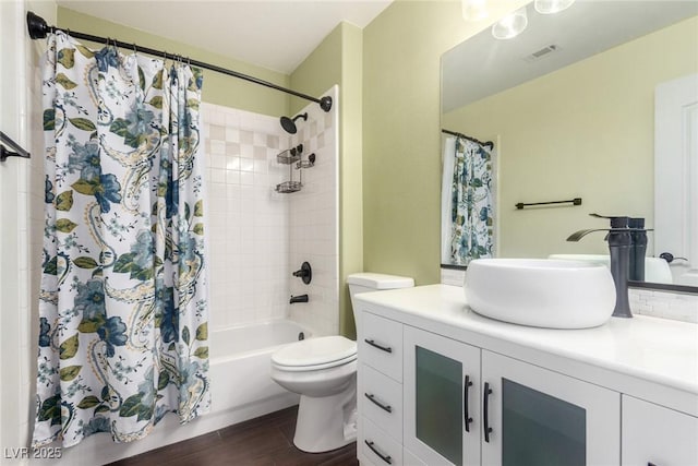 bathroom featuring visible vents, shower / bath combo with shower curtain, toilet, wood finished floors, and vanity