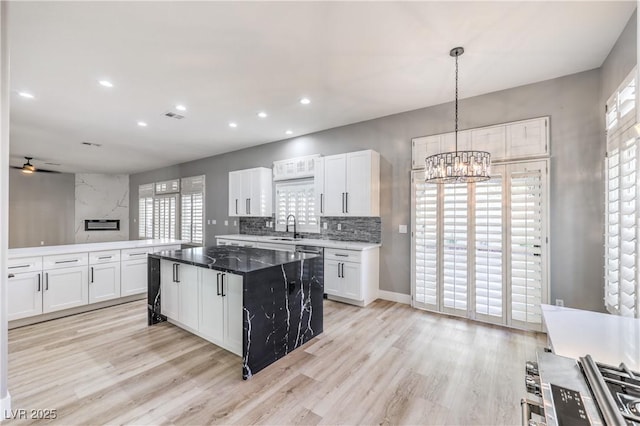 kitchen featuring white cabinets, tasteful backsplash, visible vents, and light wood-type flooring