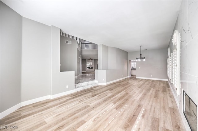 unfurnished living room with visible vents, baseboards, and light wood-style floors