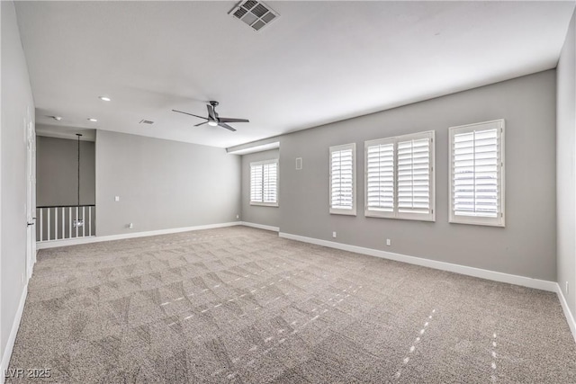 empty room featuring carpet flooring, baseboards, visible vents, and ceiling fan