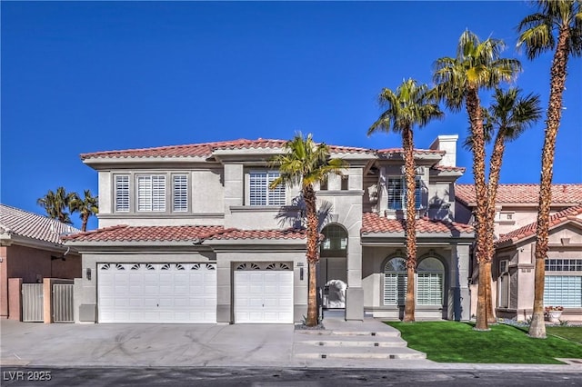 mediterranean / spanish house featuring a tiled roof, a chimney, a garage, and stucco siding