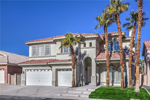 mediterranean / spanish house with stucco siding, a garage, driveway, and a tiled roof