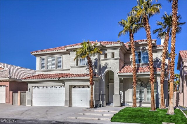8864 La Manga Ave, Las Vegas, NV 89147 - mediterranean / spanish house featuring stucco siding, a tile roof, an attached garage, and concrete driveway