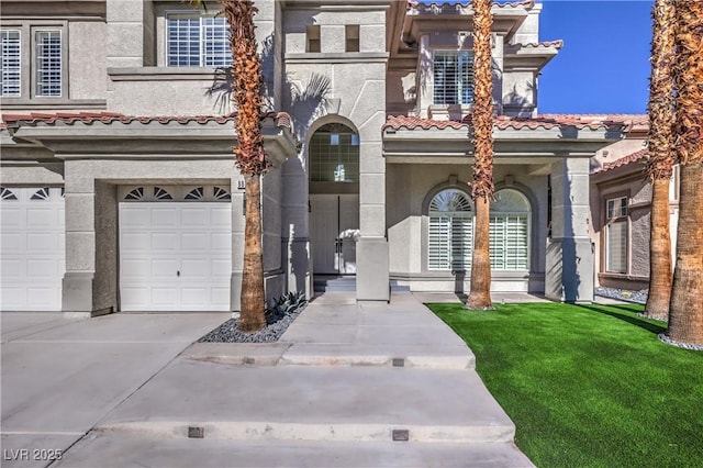 view of front of house featuring stucco siding, a garage, and a tile roof