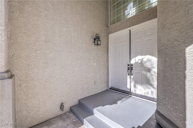 doorway to property featuring stucco siding