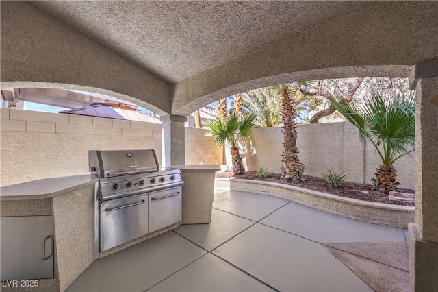 view of patio / terrace featuring a grill, exterior kitchen, and a fenced backyard