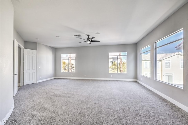 carpeted empty room featuring visible vents, baseboards, and ceiling fan