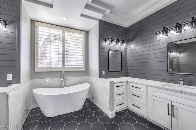 full bathroom featuring a soaking tub, wainscoting, vanity, and tile patterned flooring