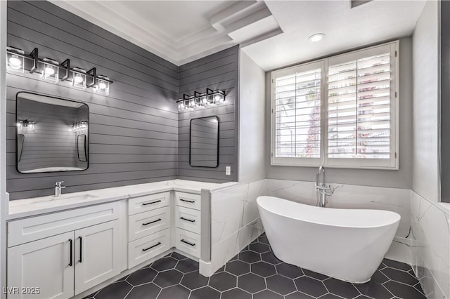 bathroom featuring tile patterned floors, wainscoting, a freestanding bath, and vanity