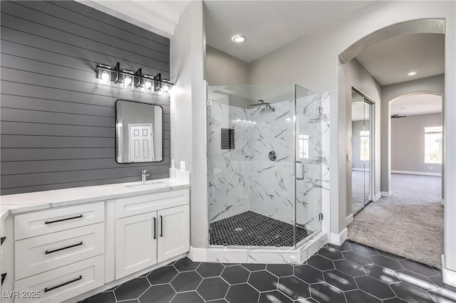 full bath with vanity, tile patterned floors, baseboards, and a marble finish shower