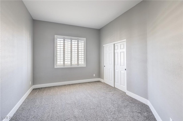 unfurnished bedroom featuring a closet, baseboards, and carpet