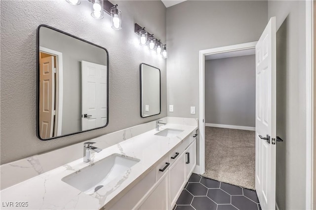 bathroom with tile patterned flooring, double vanity, baseboards, and a sink