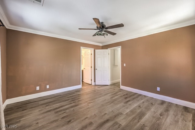 spare room featuring a ceiling fan, crown molding, wood finished floors, and baseboards