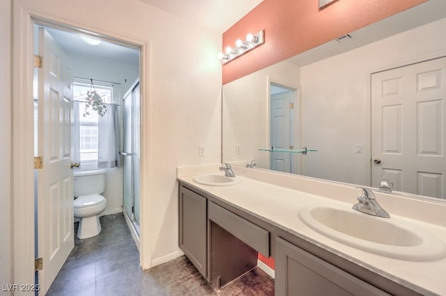 full bath featuring double vanity, a shower stall, toilet, and a sink