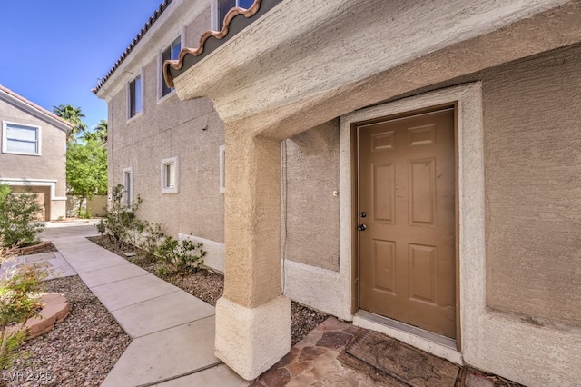 property entrance with stucco siding