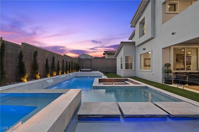 pool at dusk with an in ground hot tub, a fenced backyard, and a fenced in pool