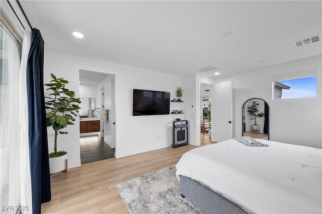 bedroom with visible vents, multiple windows, and light wood finished floors