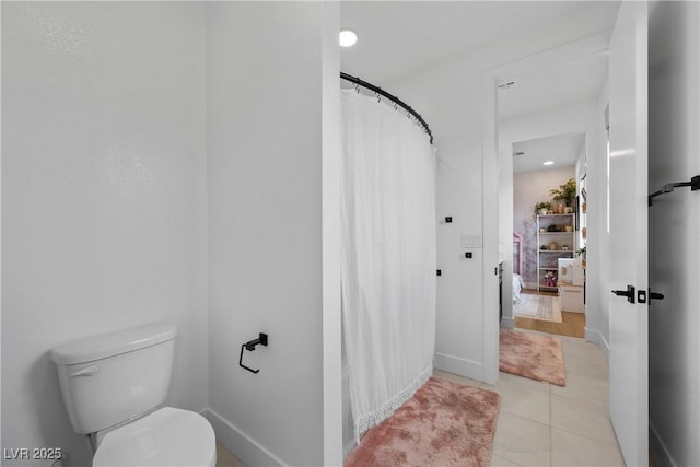 full bathroom featuring tile patterned flooring, toilet, a shower with shower curtain, and baseboards